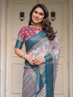 Ivory Floral Printed Saree with Rose Pink & Teal Blue Zari Border & Tassels – Elegant Festive Ethnic Wear