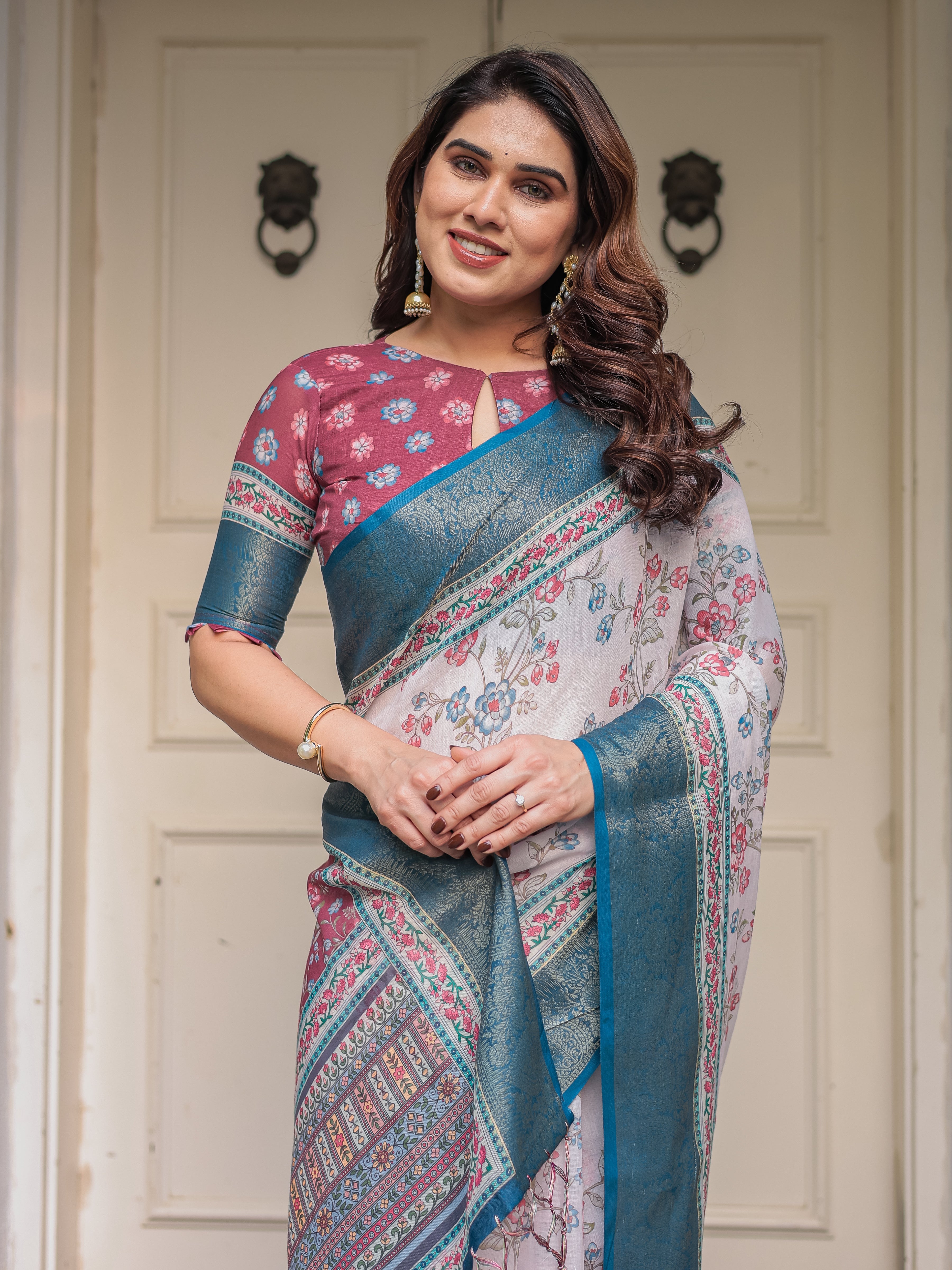Ivory Floral Printed Saree with Rose Pink & Teal Blue Zari Border & Tassels – Elegant Festive Ethnic Wear