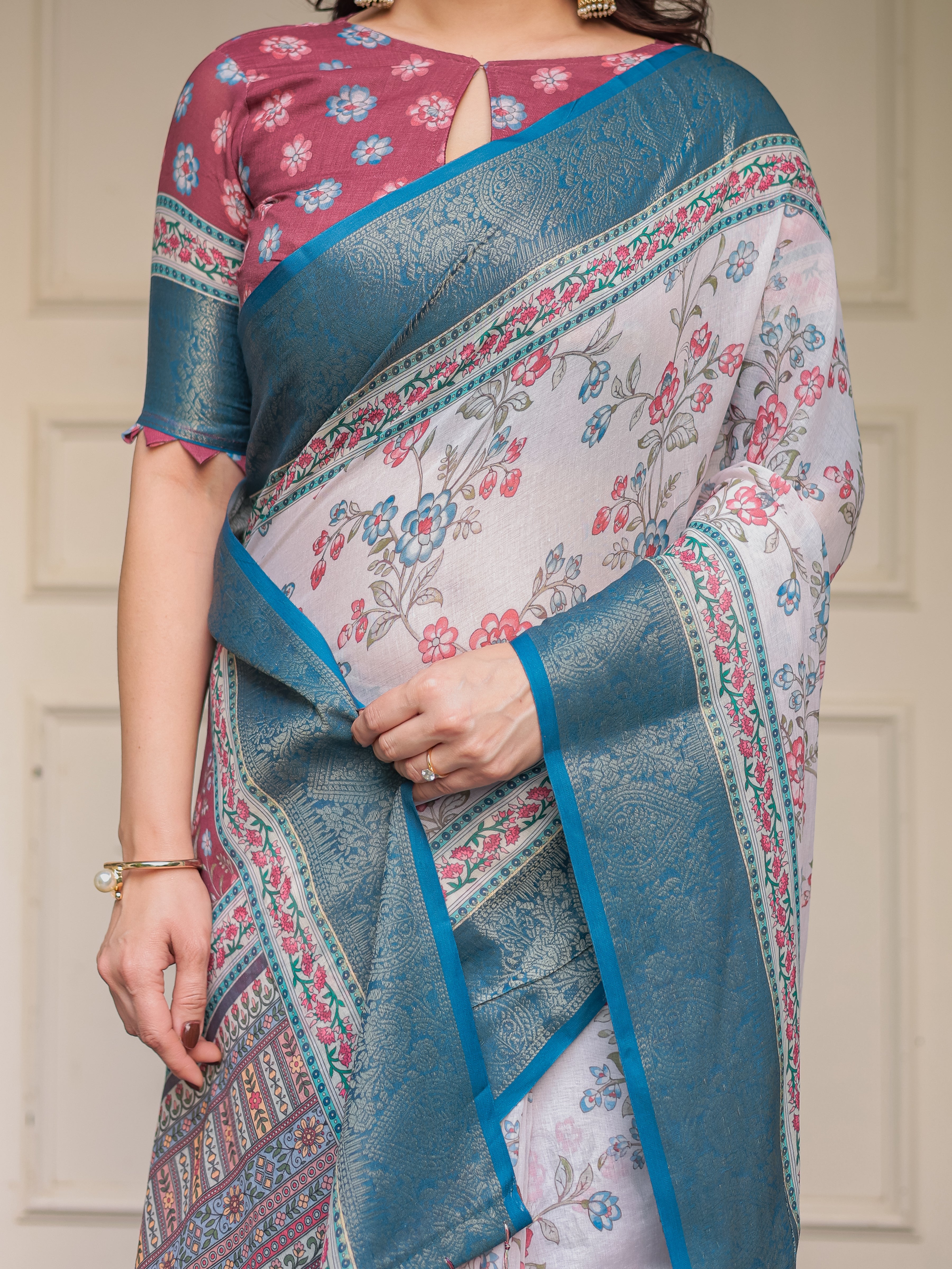 Ivory Floral Printed Saree with Rose Pink & Teal Blue Zari Border & Tassels – Elegant Festive Ethnic Wear